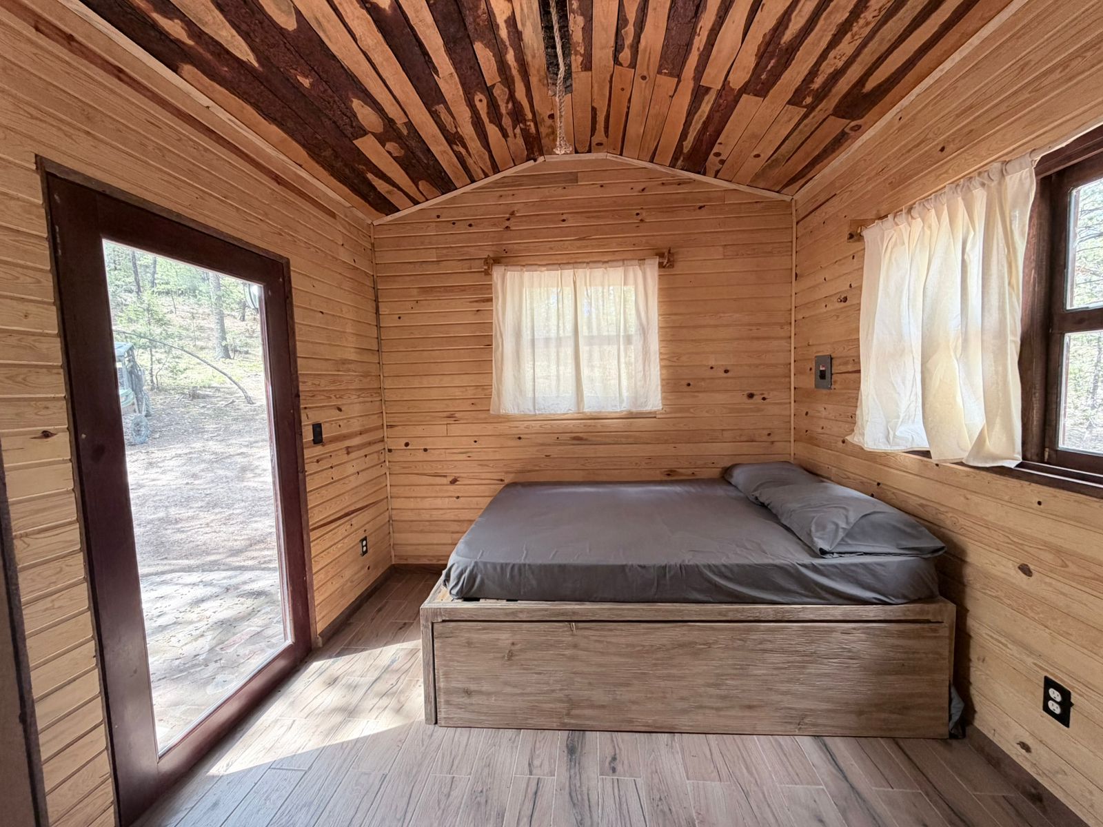 Habitación con cama y ventanal al bosque